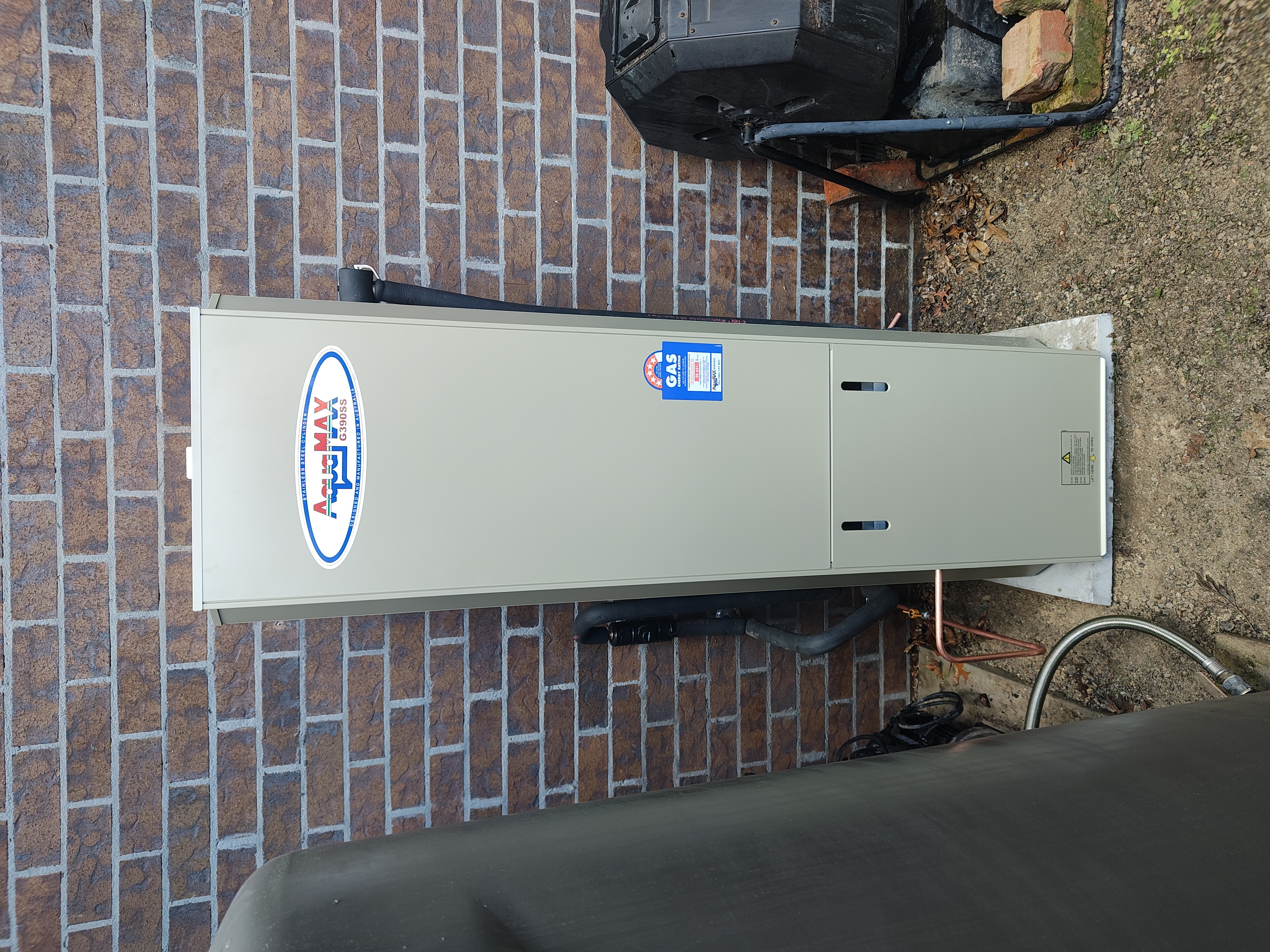 Gas hot water system installed outside a brick home