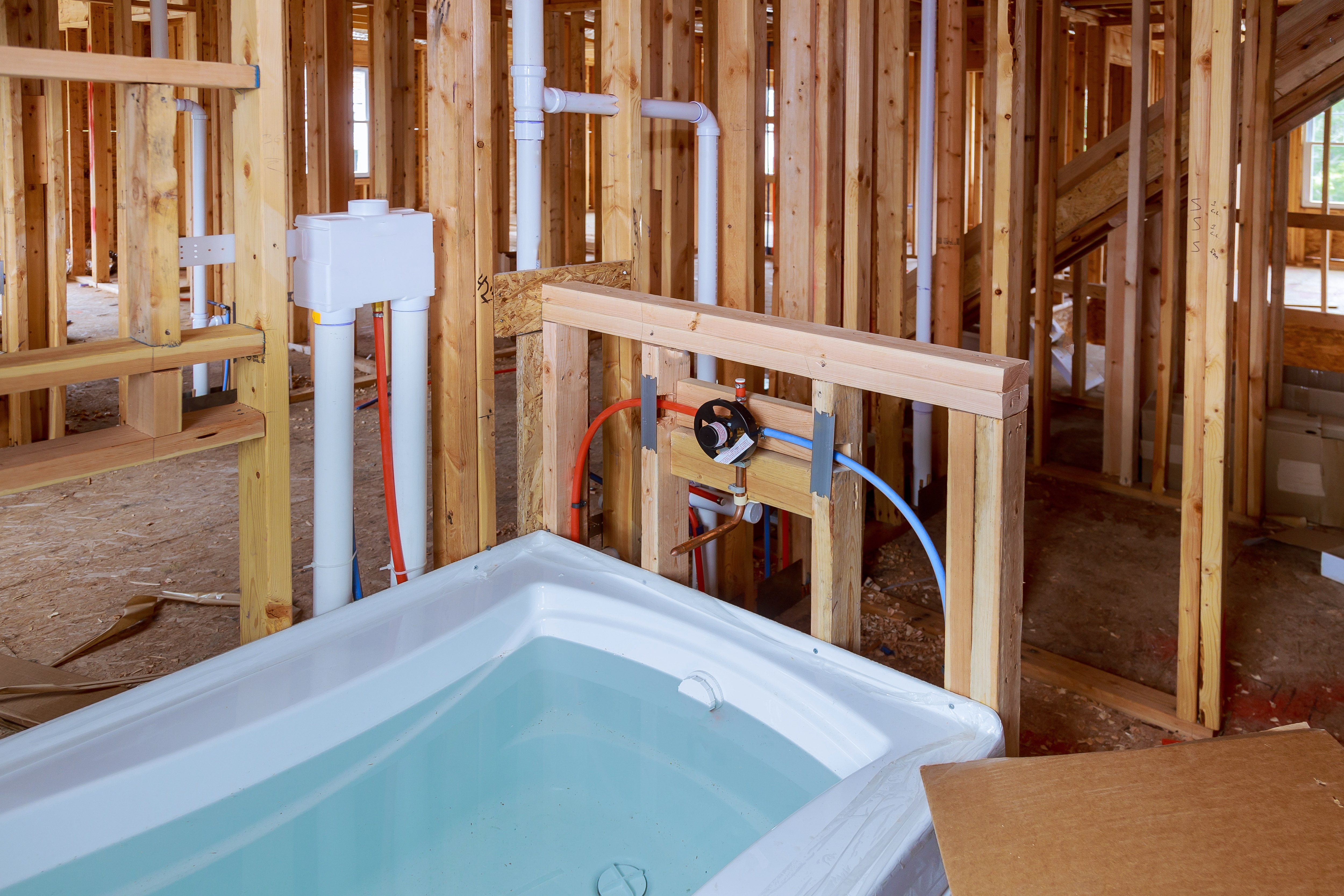 Plumbing rough in work inside a new home frame